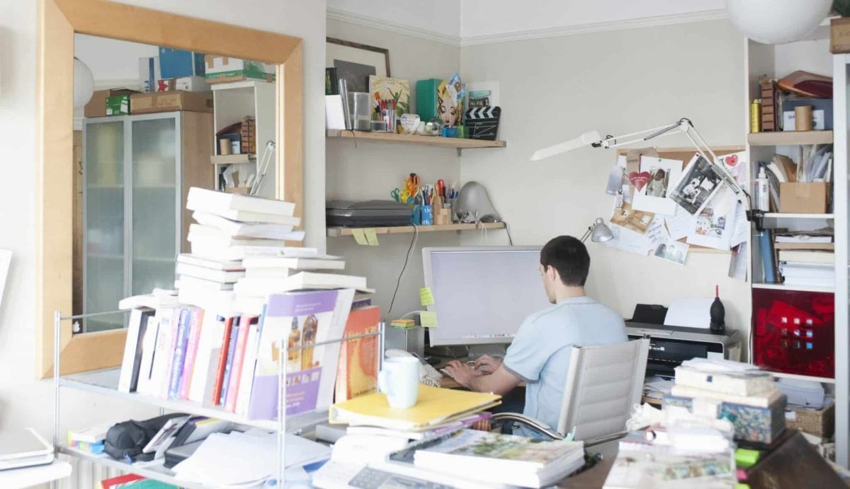 Rear view of man in cluttered home office