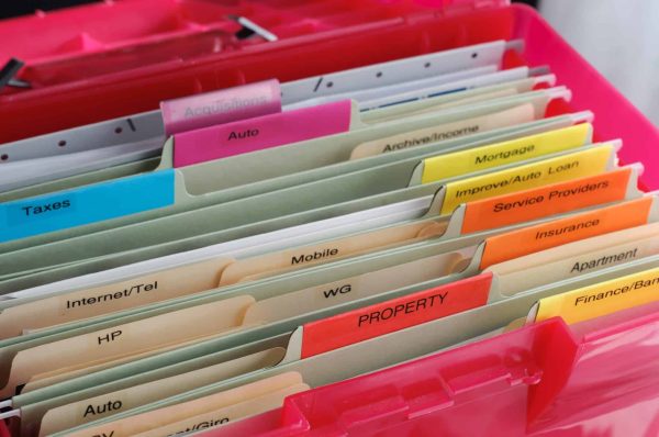 An accordion folder filled with personal documents neatly organized into labeled pockets